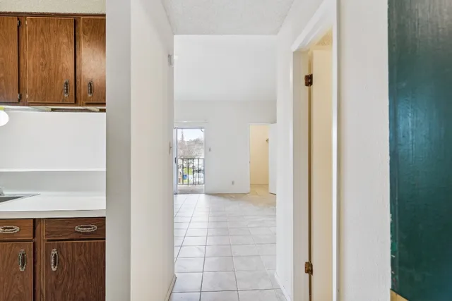 a view of a hallway with wooden cabinets