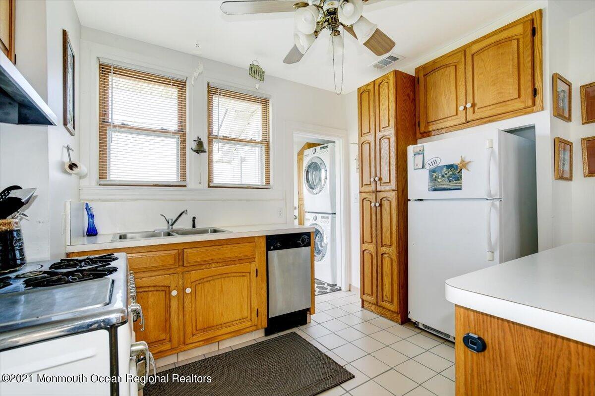 15 Riverview Road Monmouth Beach, NJ 07750 - Photo 5 of 38 a kitchen with stainless steel appliances granite countertop a refrigerator a sink dishwasher a stove and a dining table with wooden floor