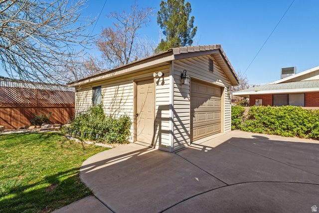 892 Cambridge Drive St. George, UT 84770 - Photo 61 of 65 Detached garage with horizontal siding, a single vehicle garage door, and an exterior door