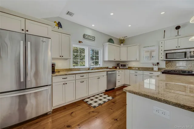 a kitchen with stainless steel appliances granite countertop a stove sink and cabinets