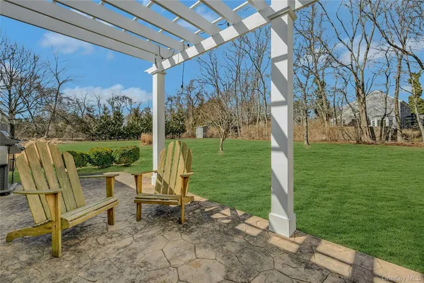 a patio with table and chairs and potted plants