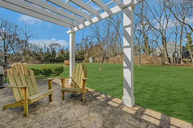 a patio with table and chairs and potted plants