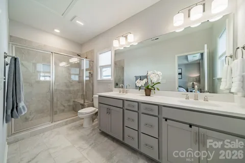a spacious bathroom with a double vanity sink mirror and toilet
