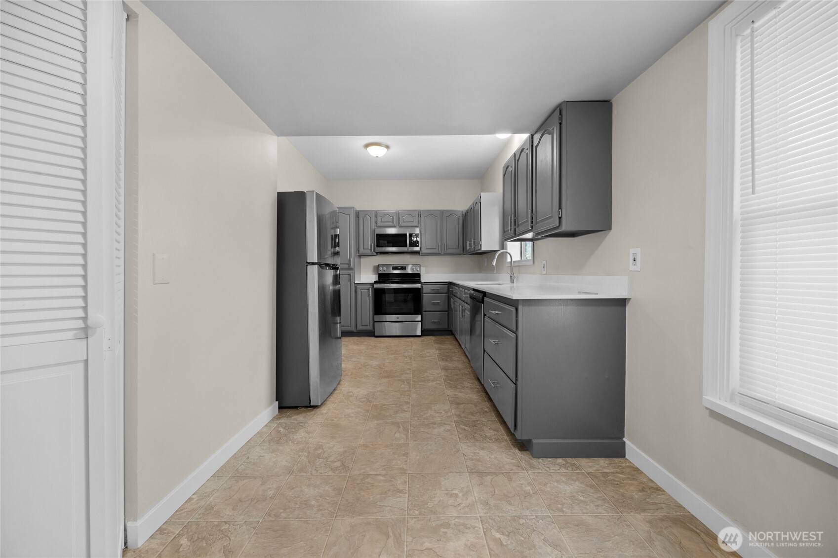 1925 Lombard Avenue, Unit A Everett, WA 98201 - Photo 6 of 25 a kitchen with stainless steel appliances granite countertop a refrigerator and a stove top oven