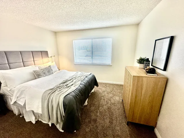 a bed sitting in a bedroom next to a window