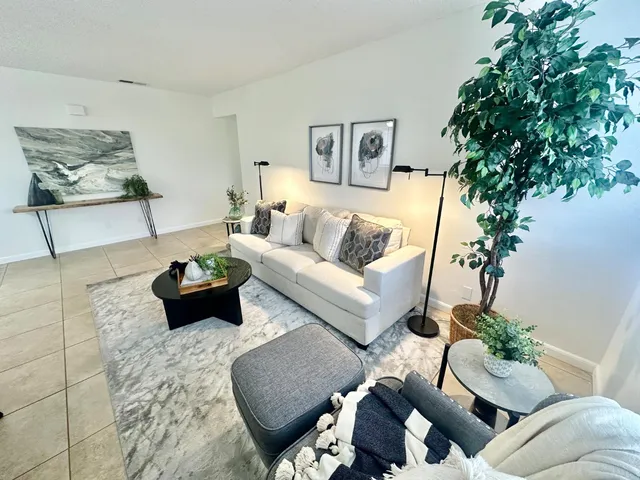 a living room with furniture and a potted plant