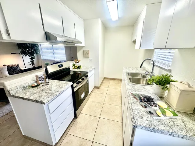 a kitchen with stainless steel appliances granite countertop a sink stove and cabinets