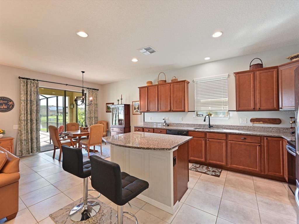 9716 58th Street East Parrish, FL 34219 - Photo 12 of 58 a large kitchen with kitchen island granite countertop a sink and cabinets