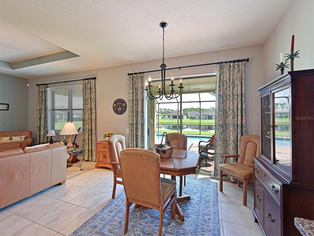 9716 58th Street East Parrish, FL 34219 - Photo 14 of 58 a living room with furniture a flat screen tv and a floor to ceiling window