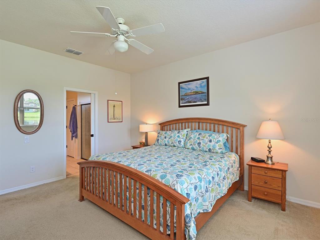9716 58th Street East Parrish, FL 34219 - Photo 18 of 58 a bedroom with a bed and a chandelier