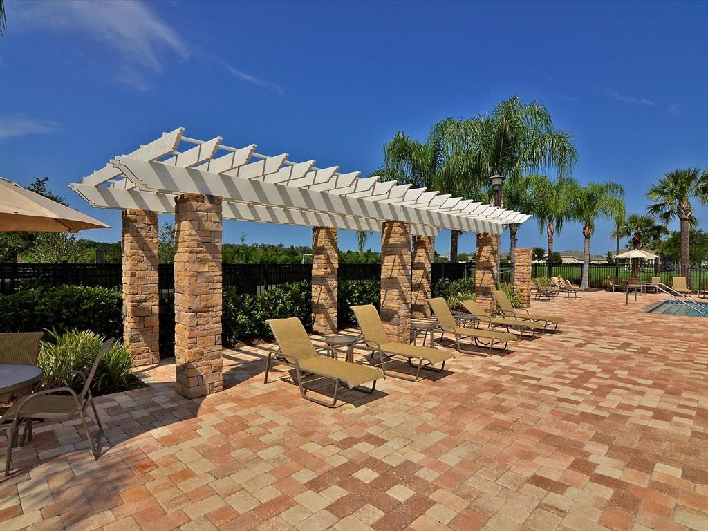 9716 58th Street East Parrish, FL 34219 - Photo 42 of 58 a view of a patio with a table and chairs under an umbrella