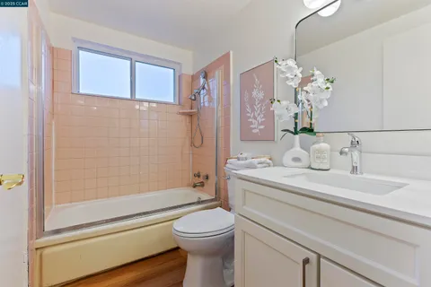 a utility room with dryer washer and a wooden floor