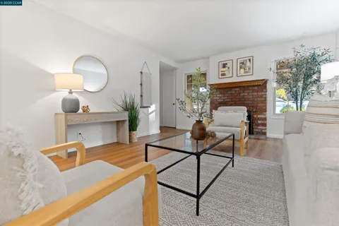 a living room with furniture a table and potted plants