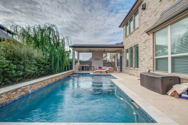 a view of swimming pool with outdoor seating and plants