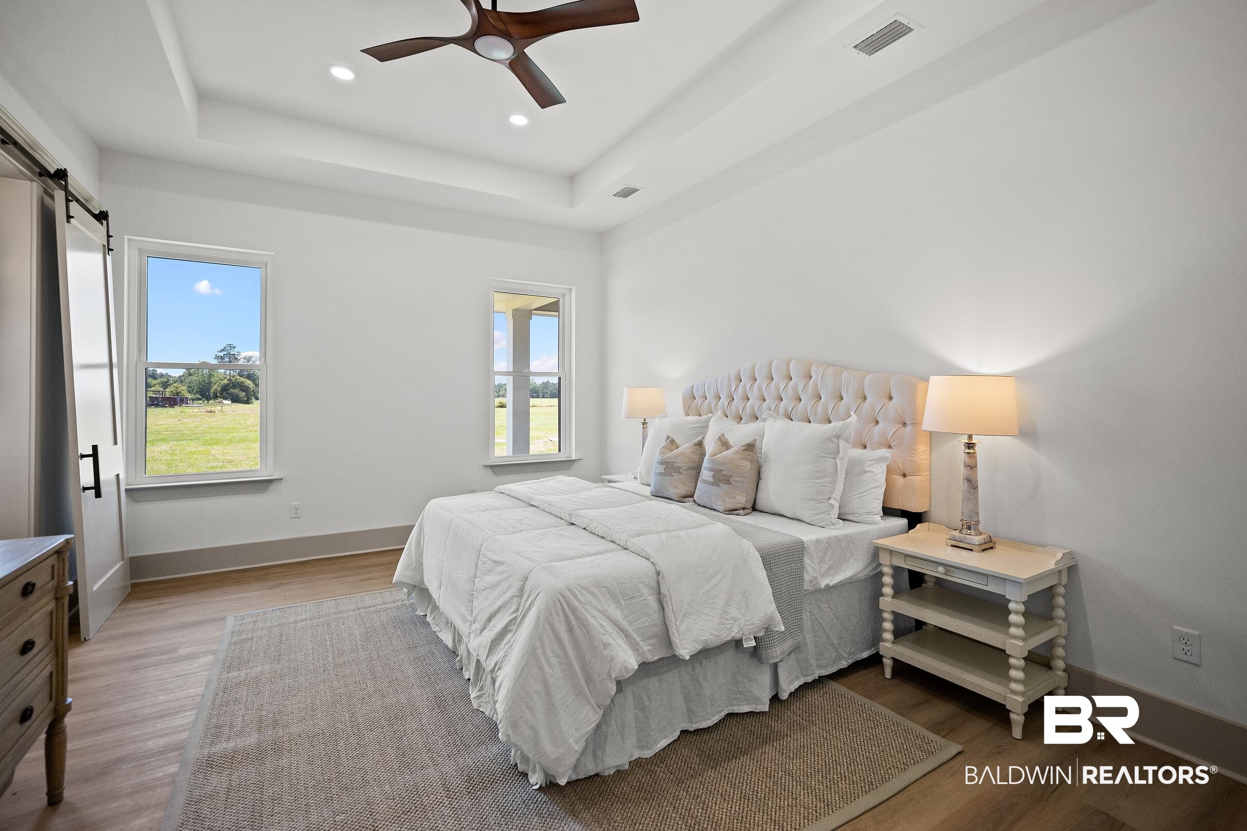13111 Gopher Court Elberta, AL 36530 - Photo 14 of 41 Bright bedroom featuring wood-finish flooring, a tray ceiling with a ceiling fan, and recessed lighting