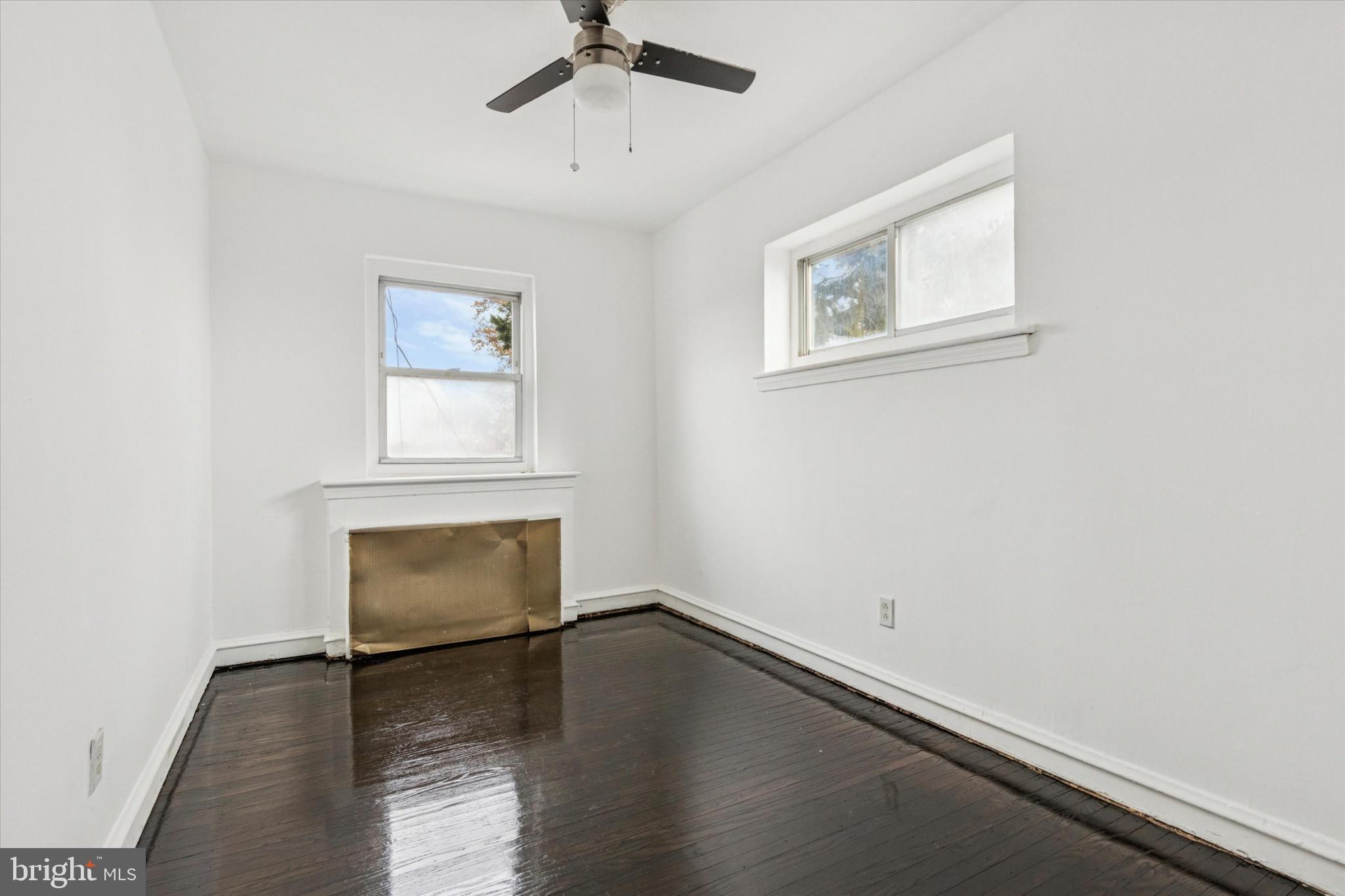 2415 80th Avenue Philadelphia, PA 19150 - Photo 28 of 35 an empty room with wooden floor a ceiling fan and windows