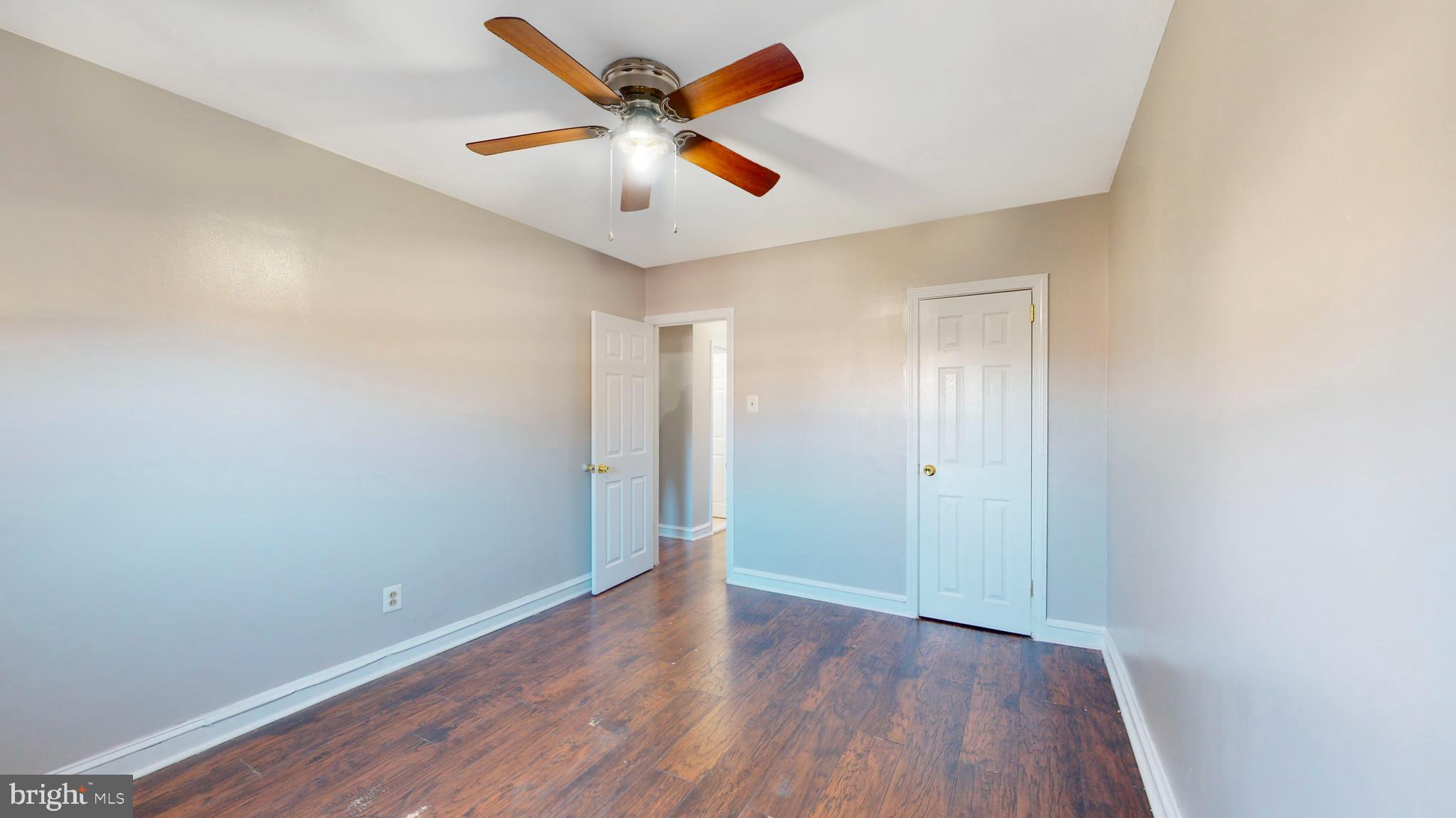 2415 80th Avenue Philadelphia, PA 19150 - Photo 8 of 35 an empty room with wooden floor and a ceiling fan