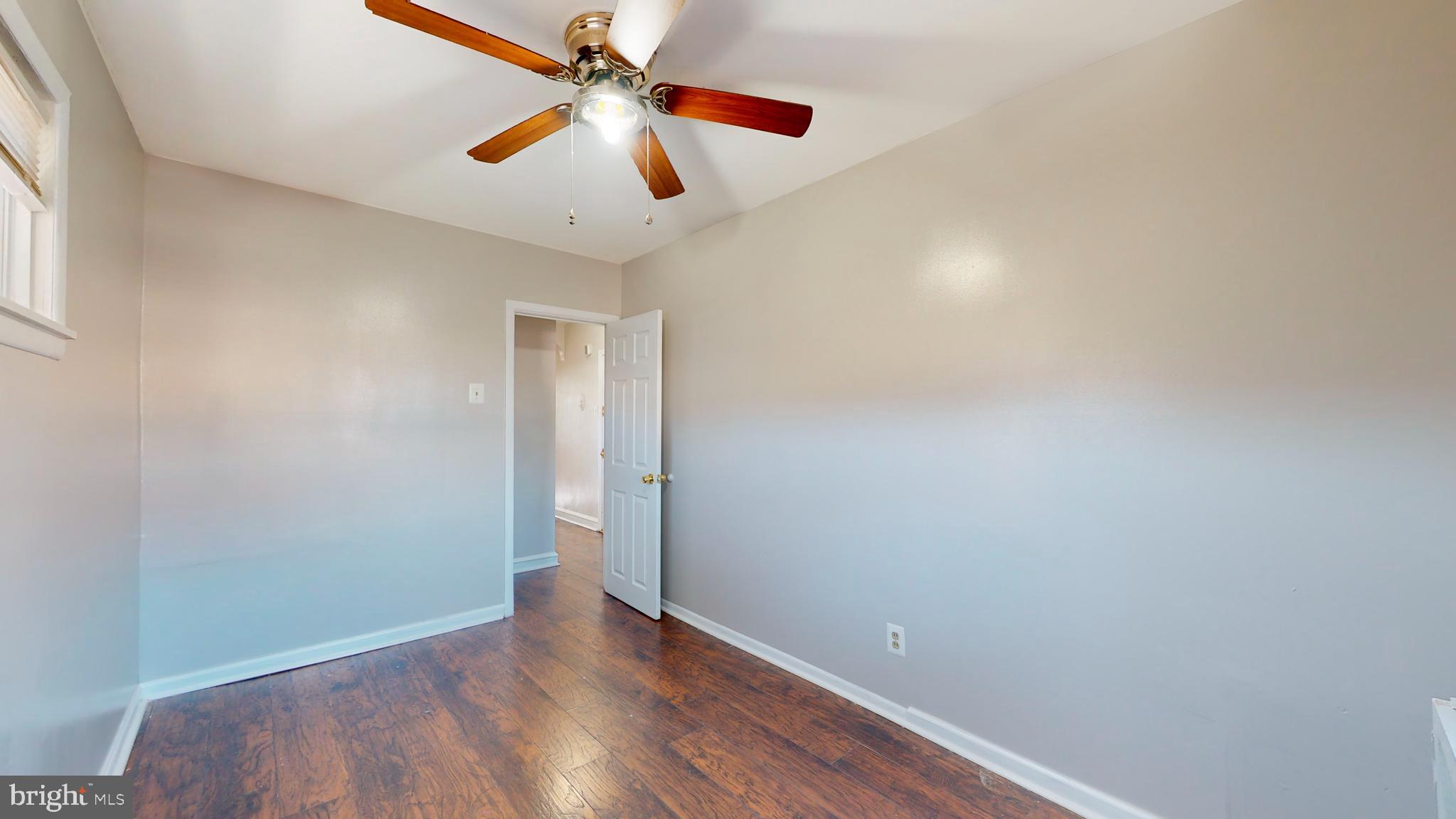 2415 80th Avenue Philadelphia, PA 19150 - Photo 10 of 35 an empty room with wooden floor ceiling fan and window