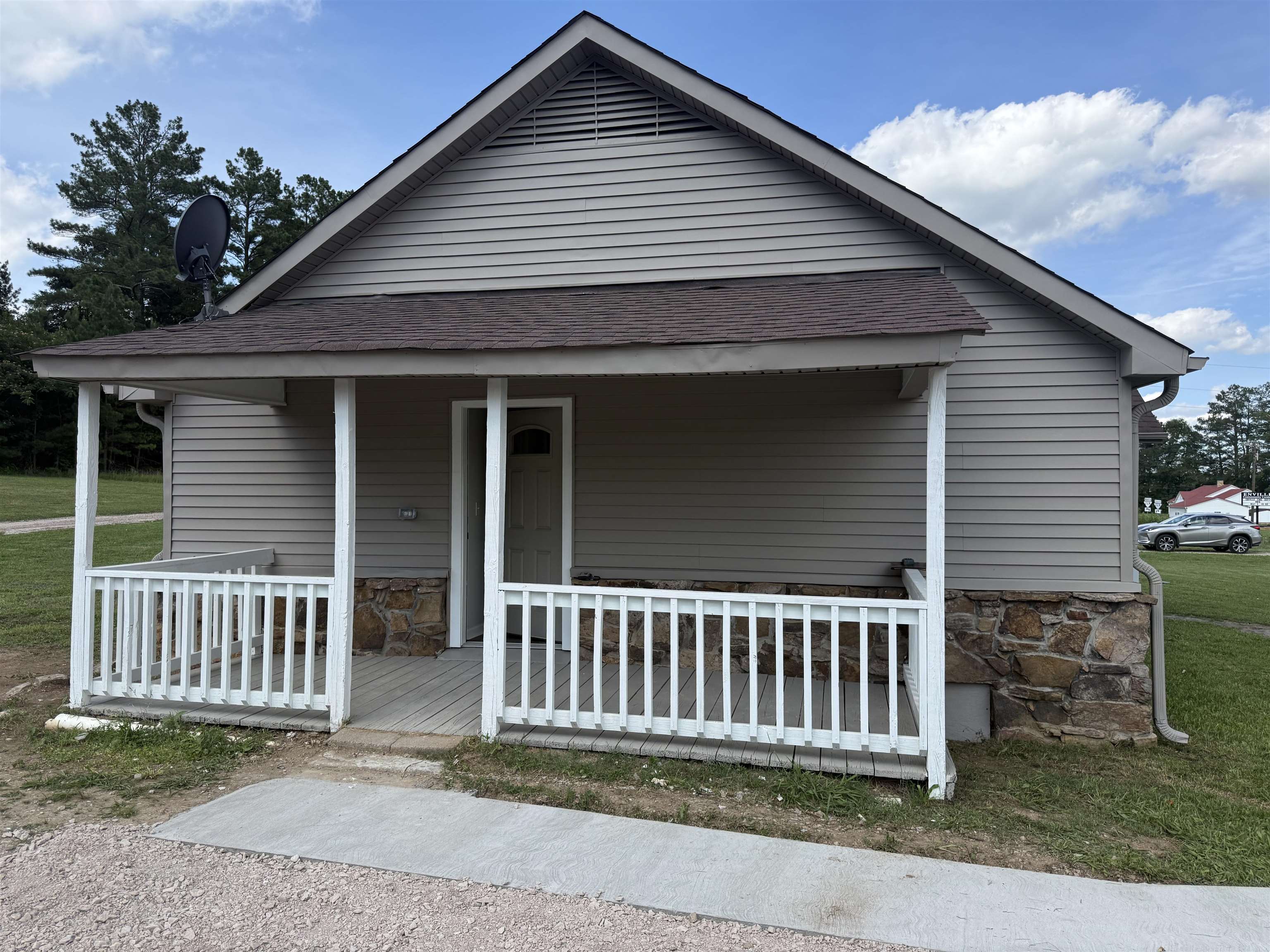 170 Leapwood Road Enville, TN 38332 - Photo 4 of 33 Front exterior featuring neutral-toned siding, a covered porch with a white railing, and a gabled roof