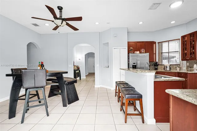 a living room with stainless steel appliances kitchen island granite countertop furniture and a view of kitchen