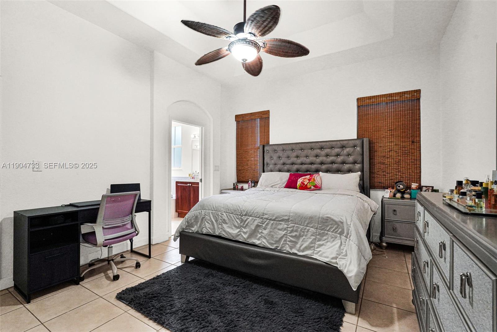 9067 Northwest 182nd Terrace Hialeah, FL 33018 - Photo 14 of 40 a bedroom with a bed and a chandelier