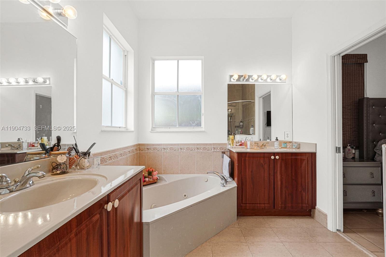 9067 Northwest 182nd Terrace Hialeah, FL 33018 - Photo 18 of 40 a bathroom with a tub sink and mirror