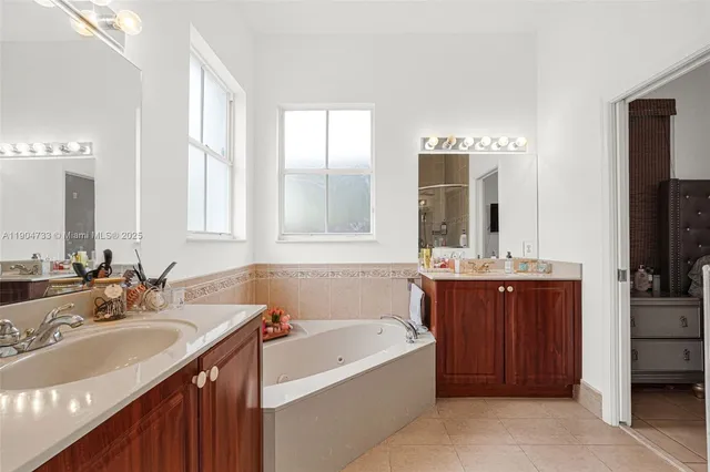 a bathroom with a tub sink and mirror