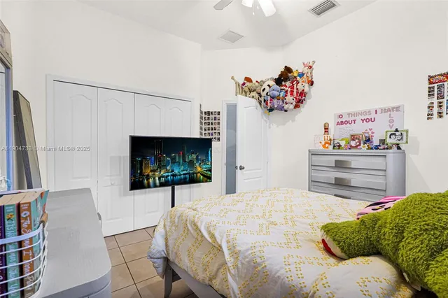 a bedroom with a bed painting on wall and a potted plant