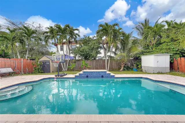 a view of a house with swimming pool and a yard