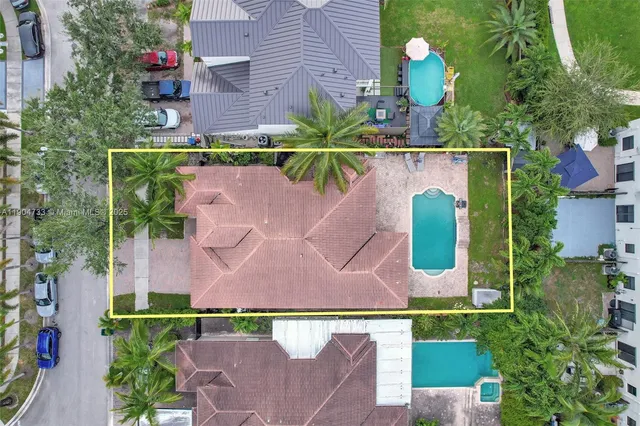 an aerial view of a house with a yard and a large pool