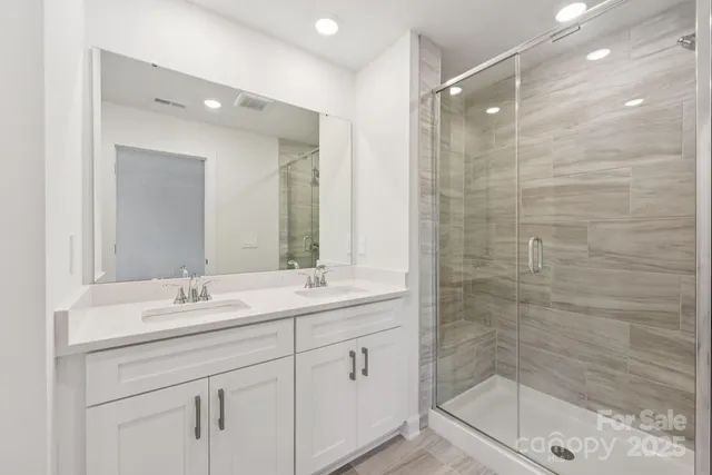 a bathroom with a shower sink and mirror