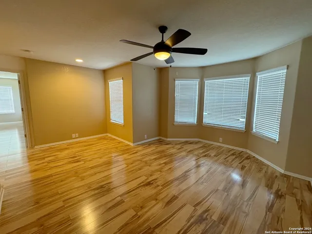 a view of an empty room with window and wooden floor