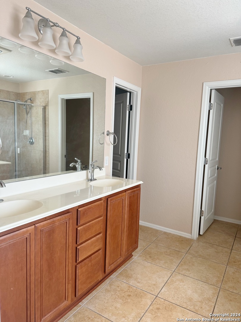 8110 Floating View San Antonio, TX 78255 - Photo 17 of 26 a bathroom with a granite countertop sink and a mirror