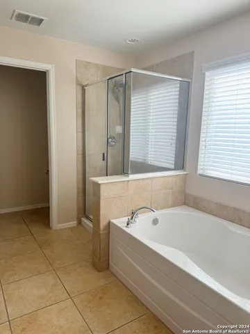 a spacious bathroom with a bathtub and a shower