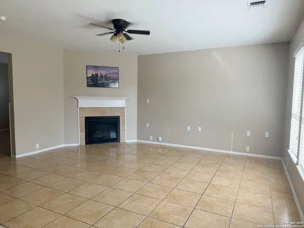 an empty room with a fireplace and fan