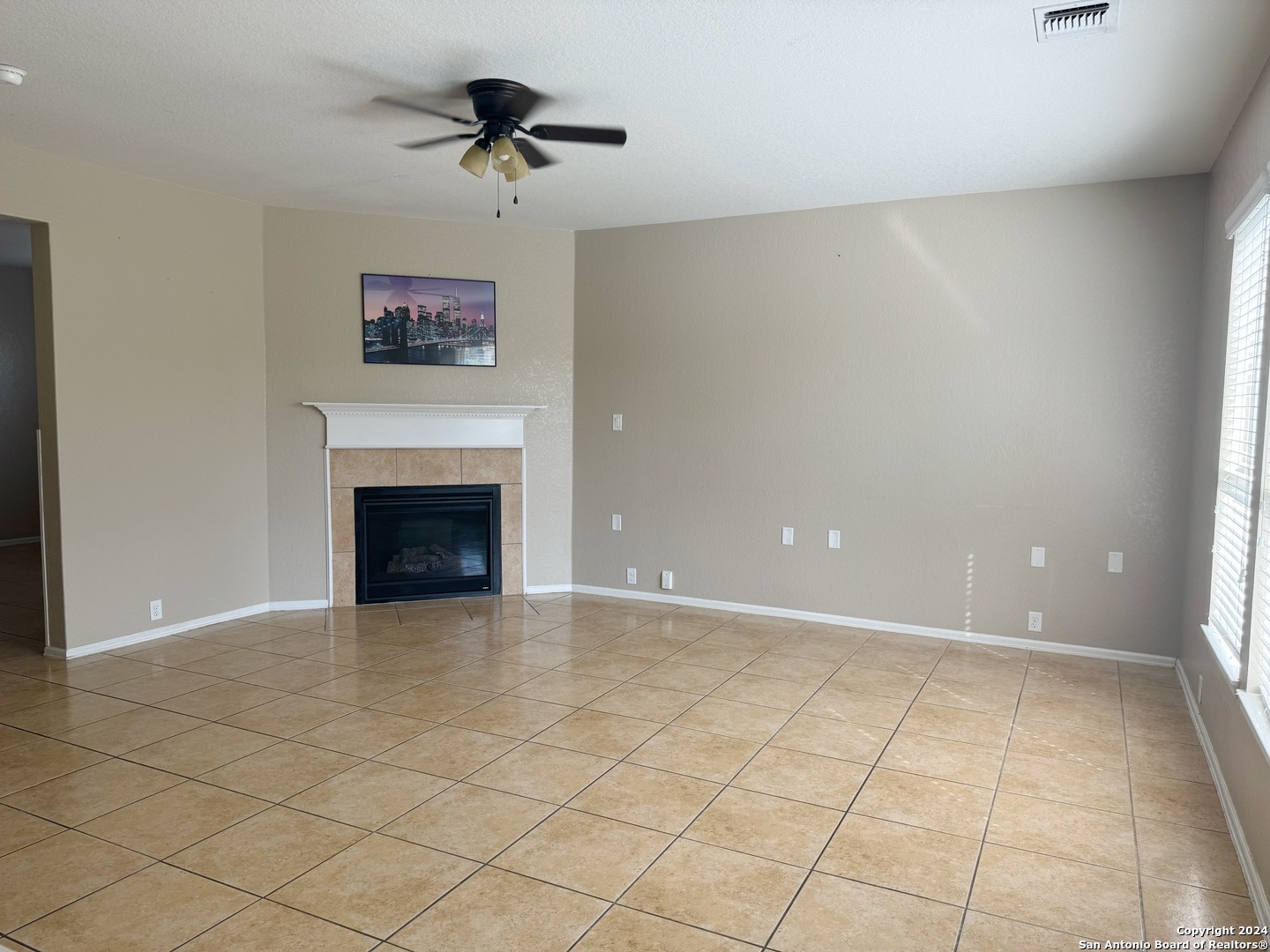 8110 Floating View San Antonio, TX 78255 - Photo 3 of 26 an empty room with a fireplace and fan