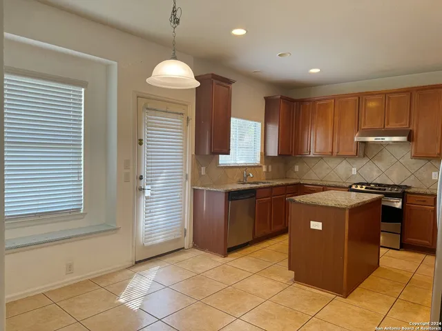 a kitchen with granite countertop a sink and a stove
