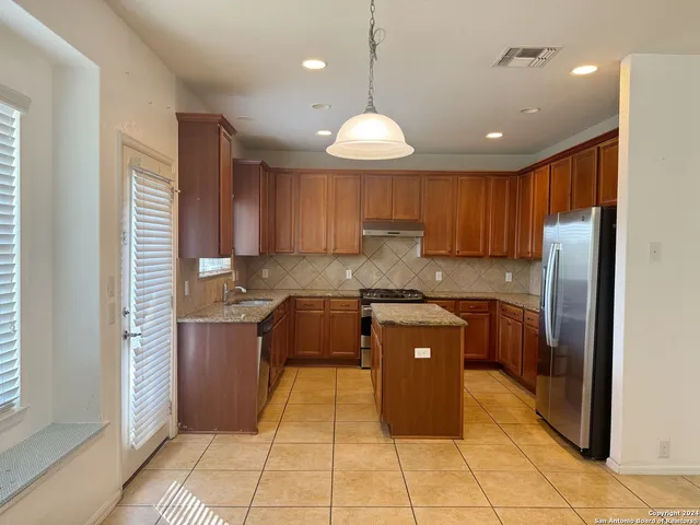 a kitchen with stainless steel appliances granite countertop a refrigerator and a stove