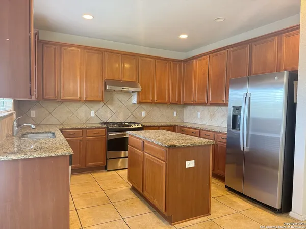 a kitchen with a refrigerator sink and cabinets