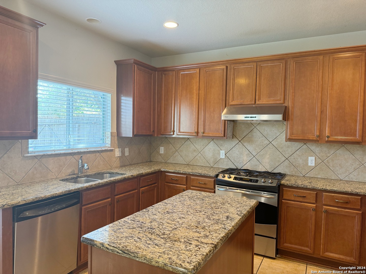 8110 Floating View San Antonio, TX 78255 - Photo 7 of 26 a kitchen with stainless steel appliances granite countertop a stove a sink dishwasher and cabinets with wooden floor