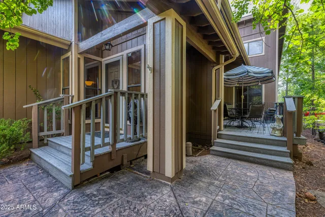 a view of a house with a small yard and large tree