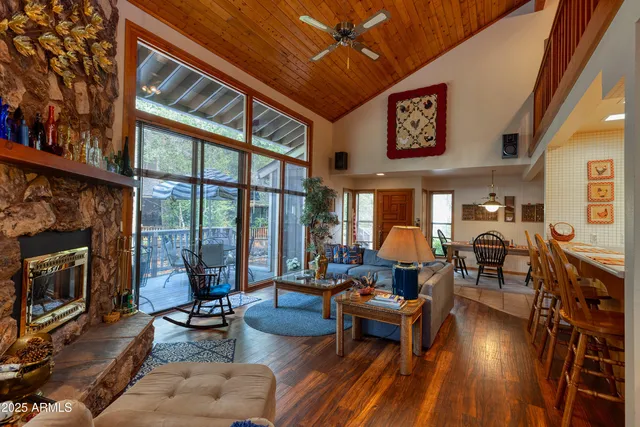 a living room with furniture a fireplace and a floor to ceiling window