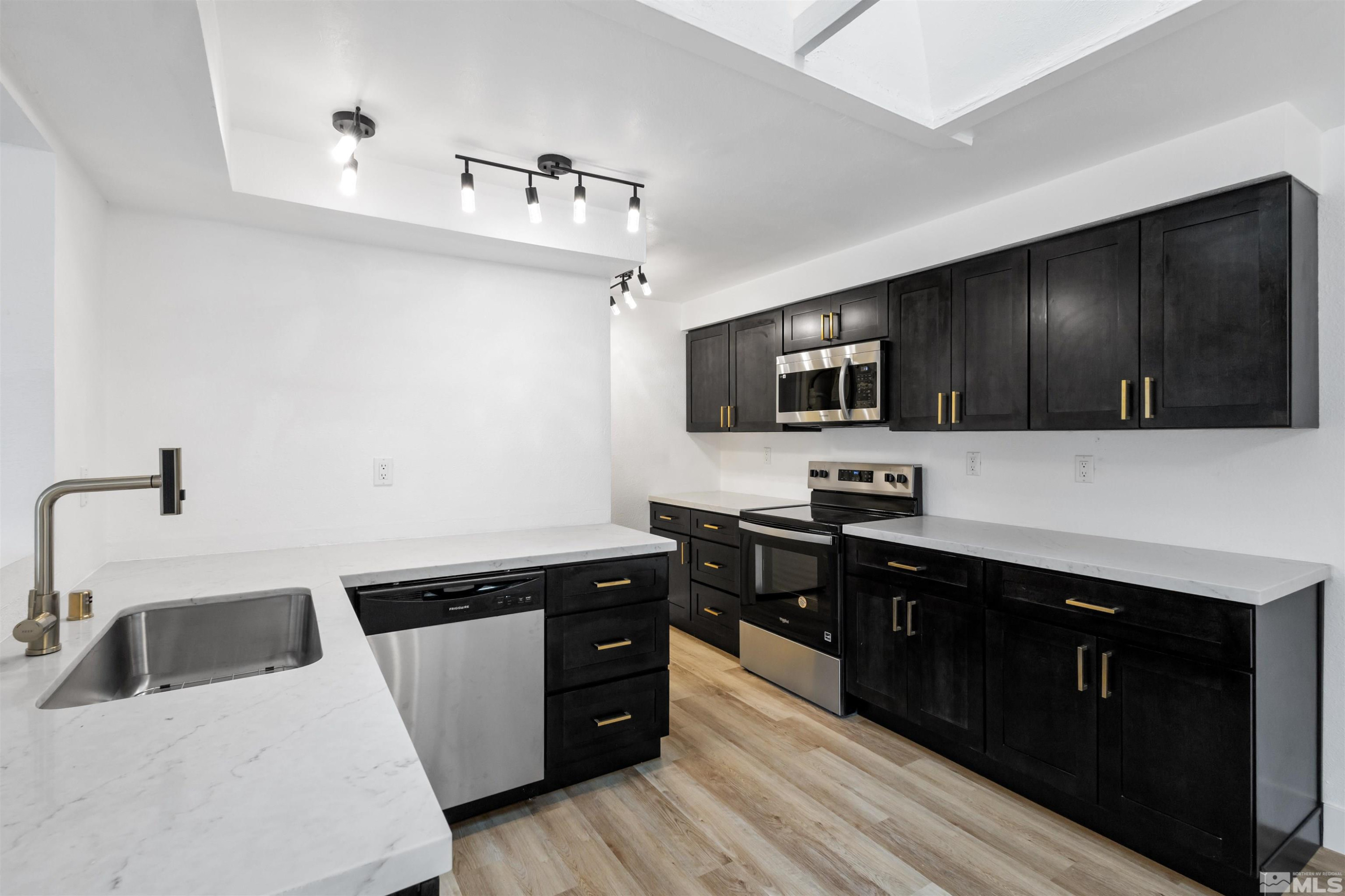 6798 Flower Street Reno, NV 89506 - Photo 1 of 22 a kitchen with stainless steel appliances a sink dishwasher stove top oven and refrigerator with wooden floor