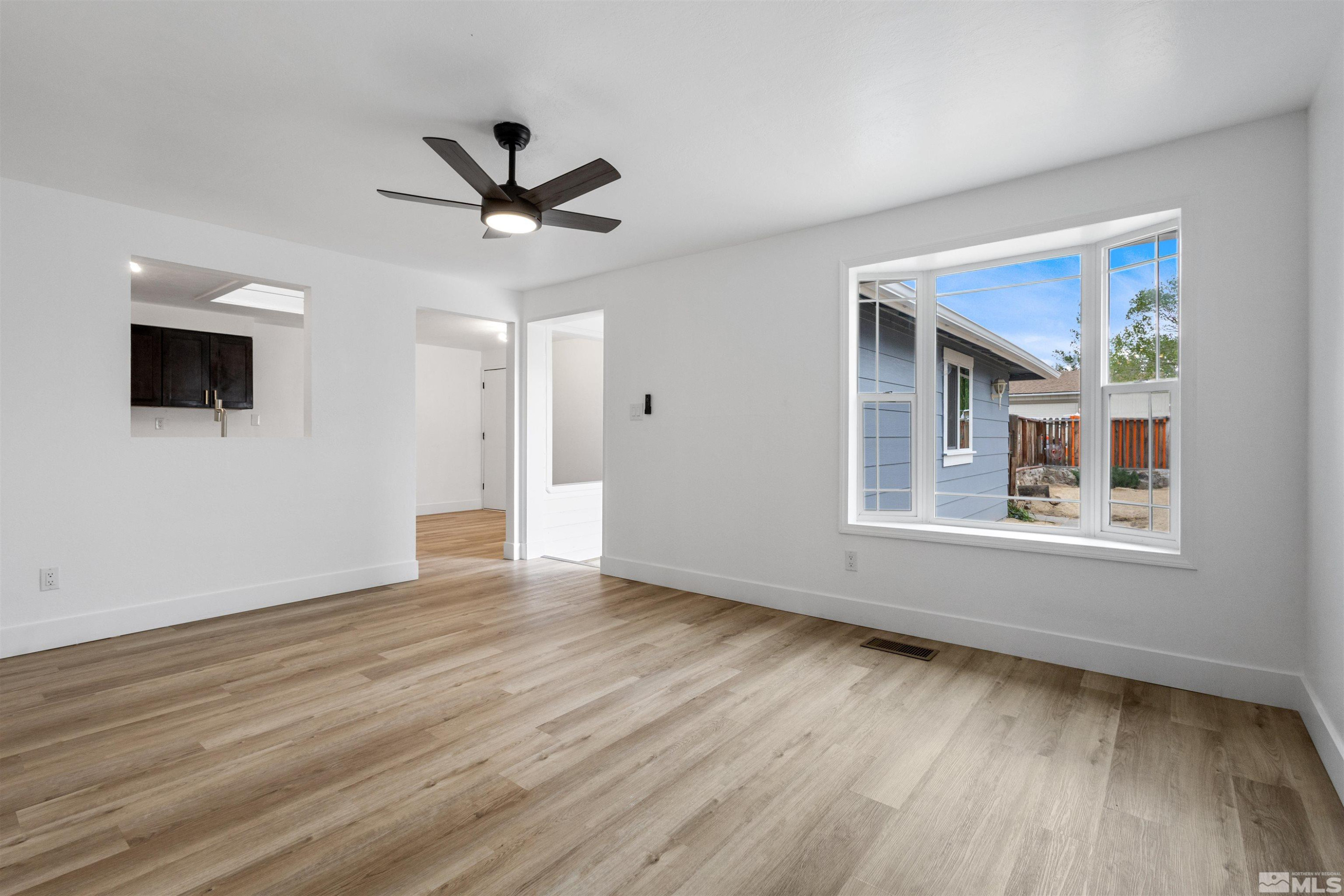 6798 Flower Street Reno, NV 89506 - Photo 6 of 22 a view of an empty room with wooden floor and a window