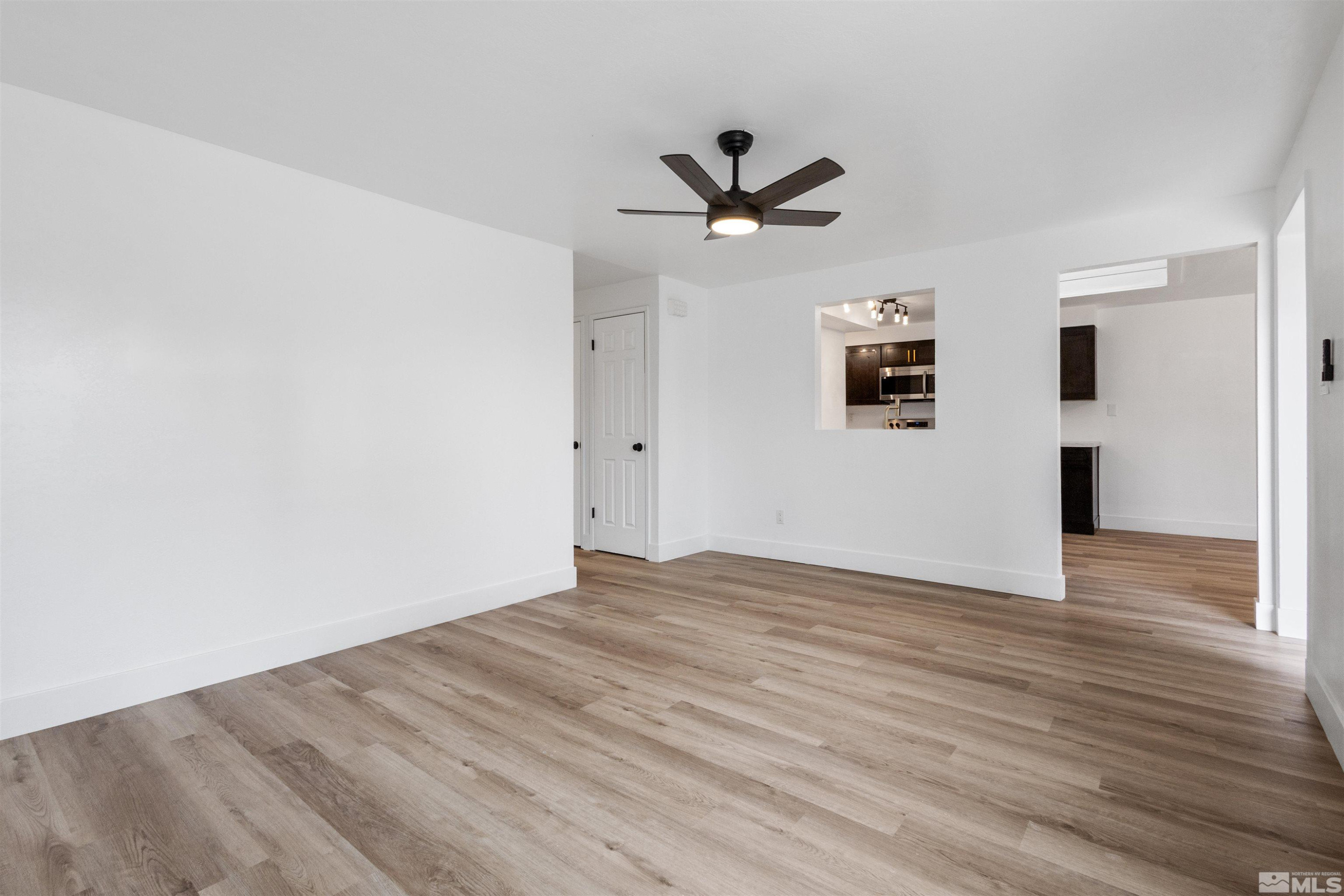 6798 Flower Street Reno, NV 89506 - Photo 7 of 22 a view of a big room with wooden floor and windows
