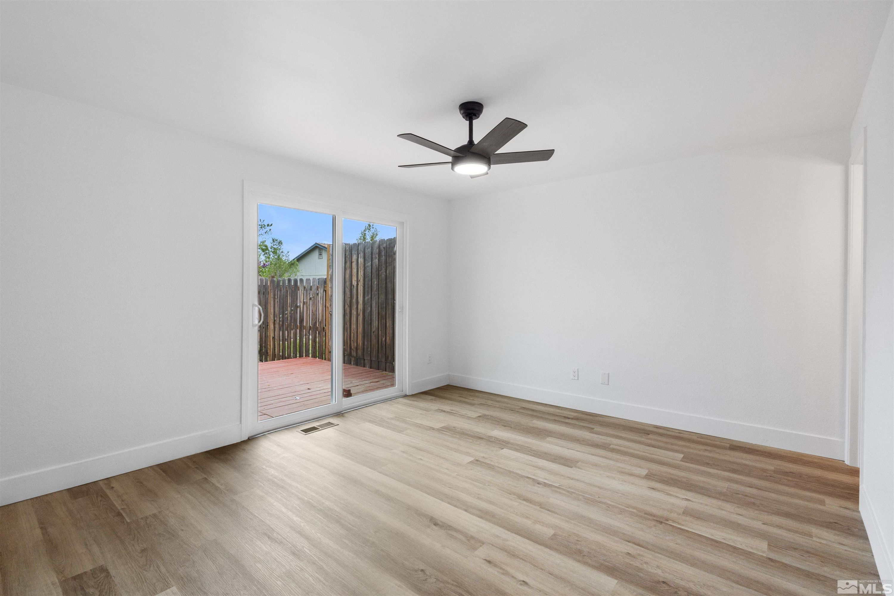 6798 Flower Street Reno, NV 89506 - Photo 9 of 22 an empty room with wooden floor and windows