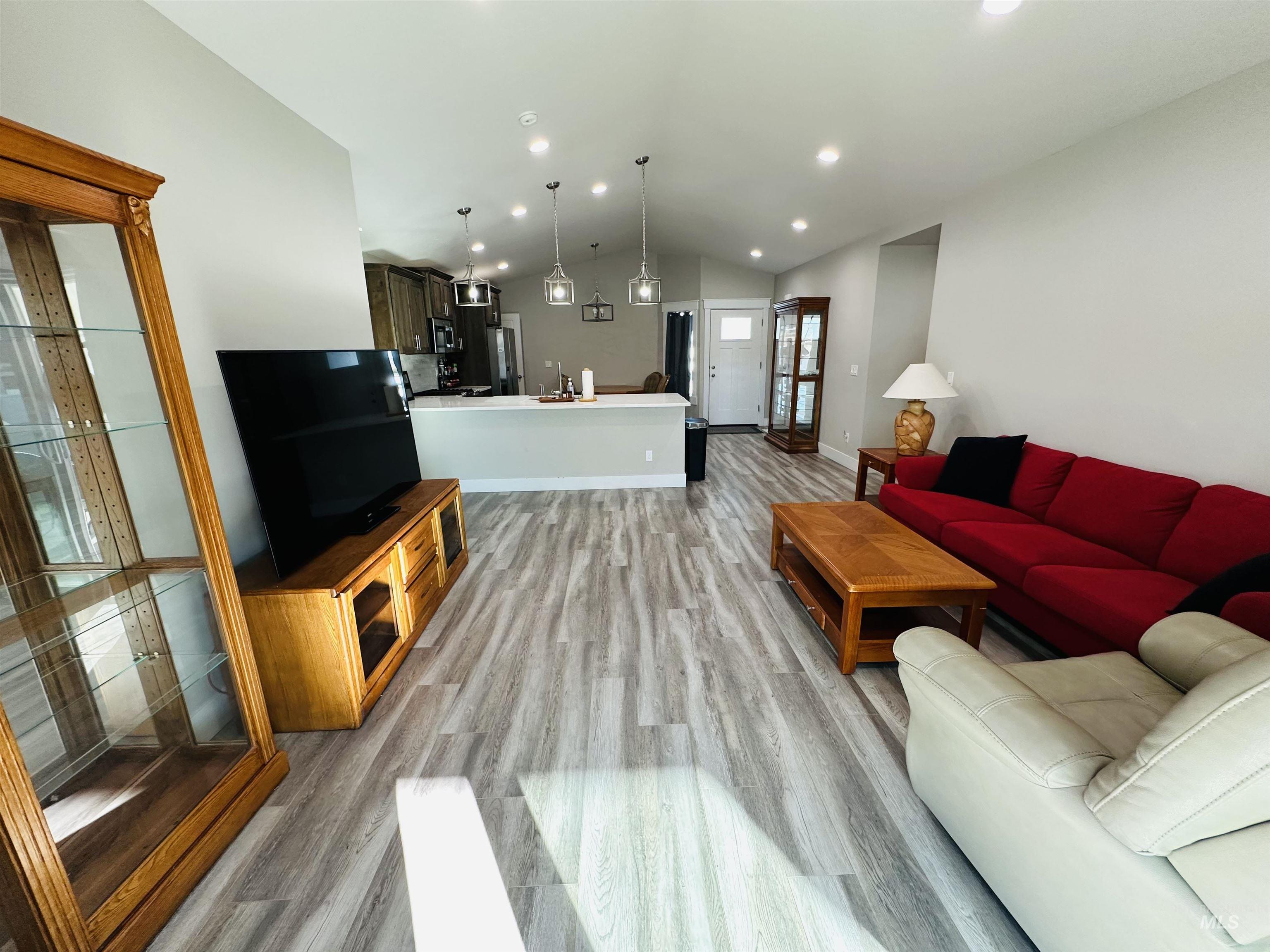 911 Campbell Street Vale, OR 97918 - Photo 9 of 37 Living room featuring vaulted ceiling, recessed lighting, and light wood-style floors