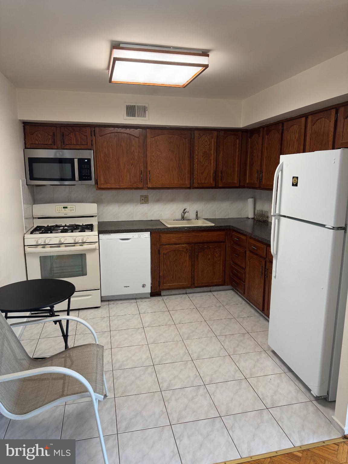 a kitchen with a cabinets and white appliances