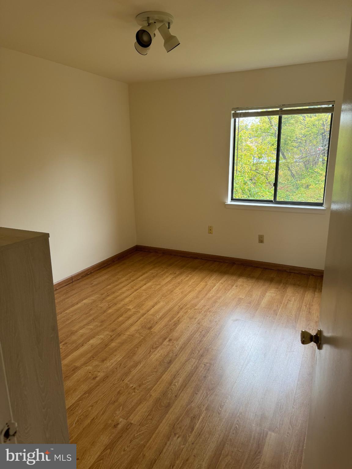 9908-00 Bustleton Avenue, Unit D2 Philadelphia, PA 19115 - Photo 7 of 11 a view of an empty room with wooden floor and a window