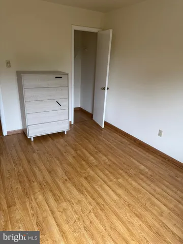 a view of an empty room with closet and cabinet